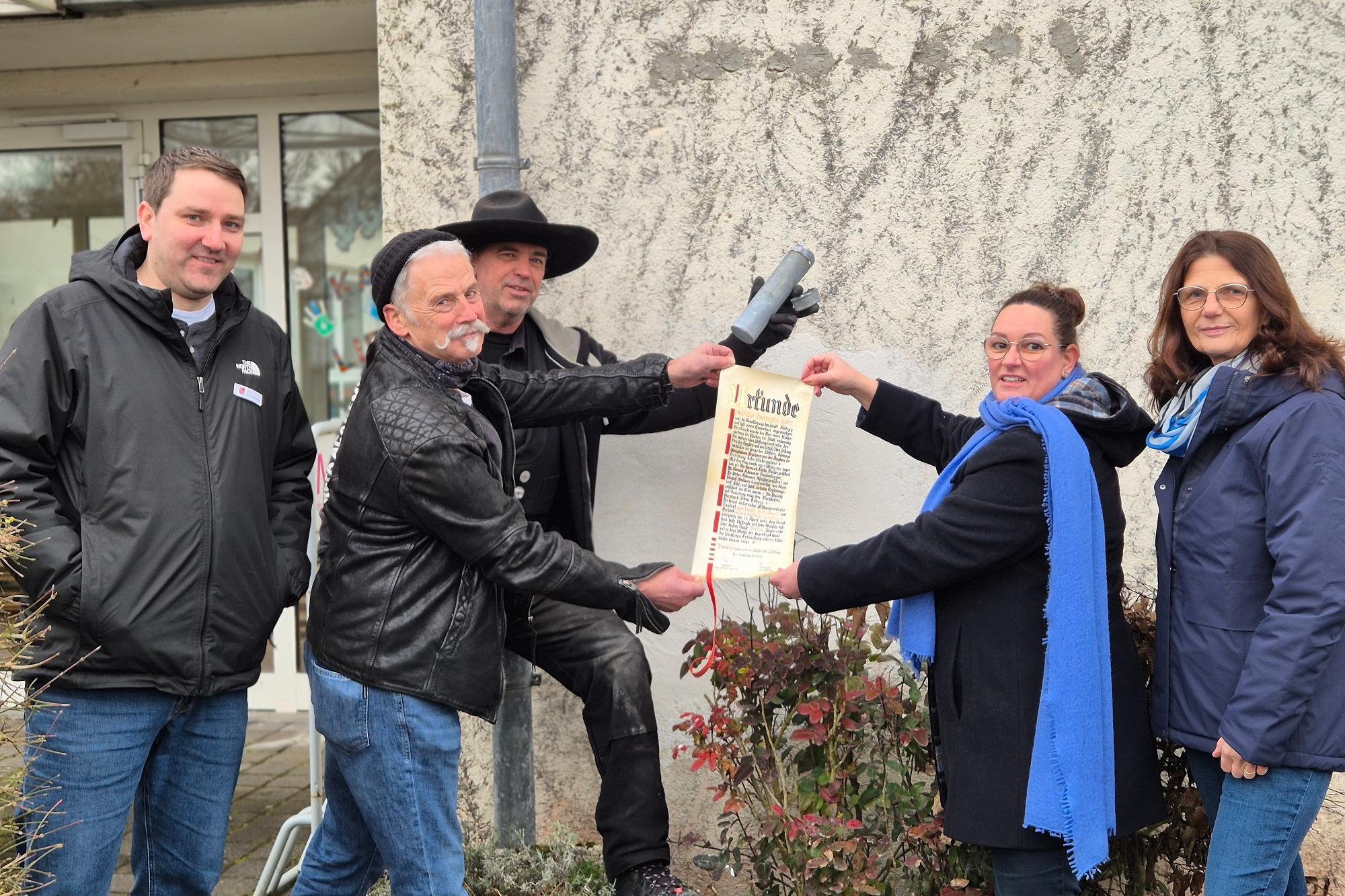 Personen zeigen die Urkunde.