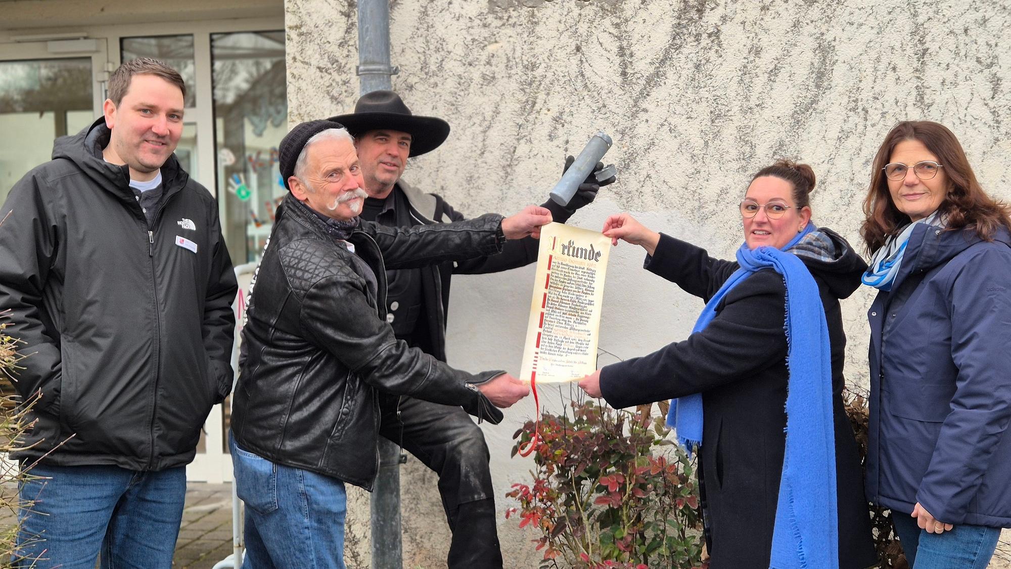 Personen zeigen die Urkunde.